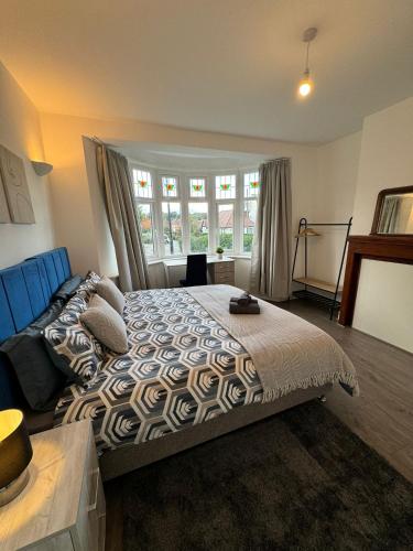 a bedroom with a bed and a large window at Smart ROOMS Easy access to Central London By Piccadilly Line in New Southgate