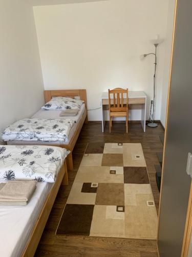 a room with two beds and a desk and a chair at U lesního muže in Střelice