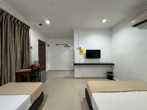 a hotel room with two beds and a television at Lan Village in Mersing