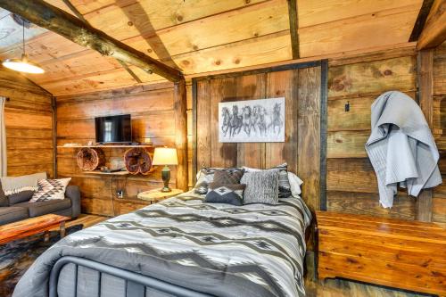 een slaapkamer met houten wanden, een bed en een bank bij Quaint Abbeville Cabin Studio with Gas Grill! in Abbeville