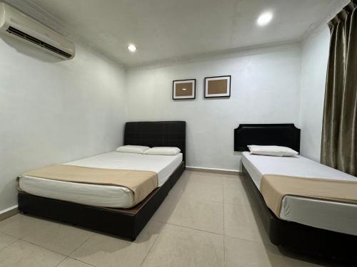 two beds in a small room with two at Lan Village in Mersing