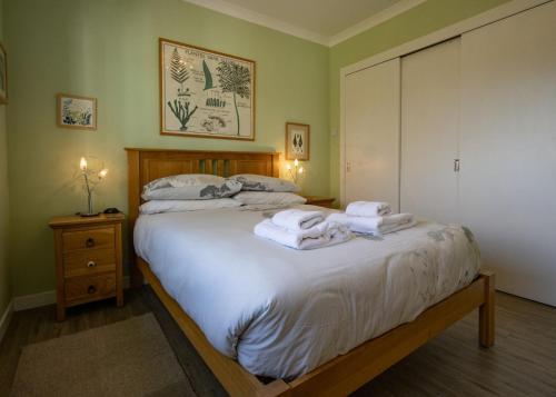 a bedroom with a bed with towels on it at Taigh a'Chaorainn in Spean Bridge