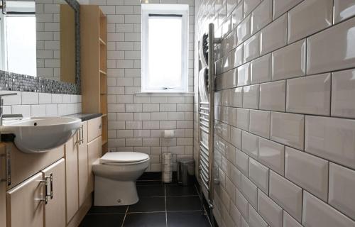 a bathroom with a toilet and a sink and a window at Taigh a'Chaorainn in Spean Bridge