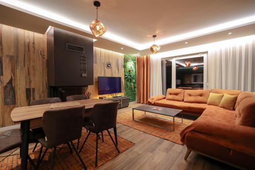 ein Wohnzimmer mit einem Sofa und einem Tisch in der Unterkunft Moments Villas Premium, Prevalle in Prizren