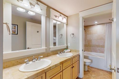 a bathroom with two sinks and a toilet and a mirror at Grand Sandestin 2422 in Destin