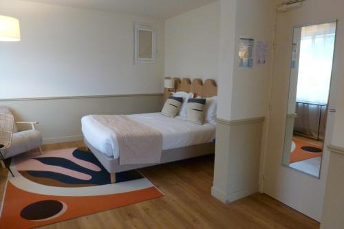a bedroom with a bed with white sheets and pillows at Family Golf Hotel in Royan