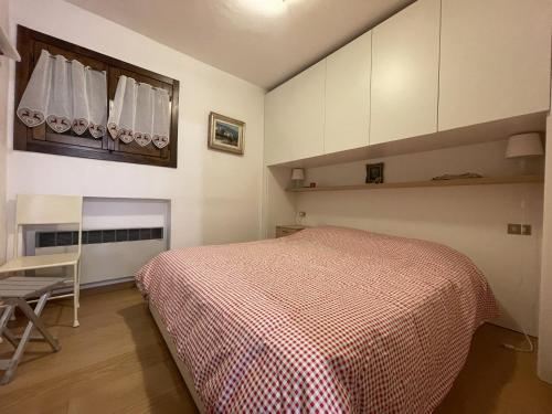 a bedroom with a bed and a table in it at 079 Bilocale, Pinzolo in Pinzolo