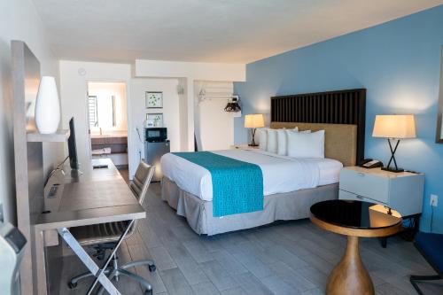 Habitación de hotel con cama grande y escritorio. en Howard Johnson by Wyndham Clearwater - Dunedin, en Clearwater