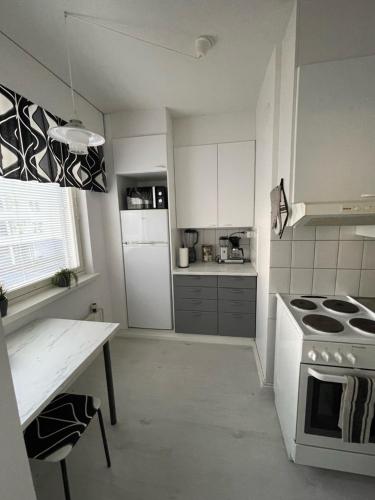 a kitchen with a stove and a white refrigerator at Kaksio Koulukatu in Lappeenranta