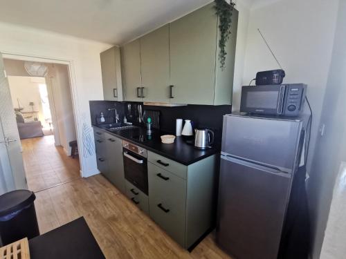 a kitchen with a refrigerator and a microwave at Petit Radet 350m de la plage in Les Sables-dʼOlonne