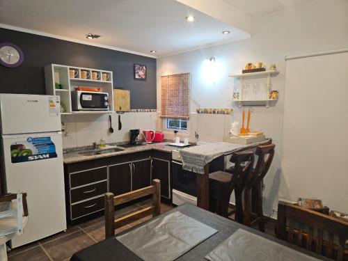 a small kitchen with a table and a refrigerator at Luz Del Alma in Las Gaviotas