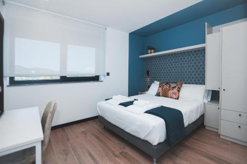 1 dormitorio con cama y pared azul en Alma Candida 22, en Valença
