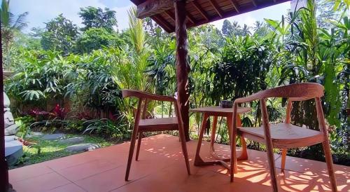 two chairs and a table on a porch at PONDOK KUNGKANG VILLA 2 in Ubud