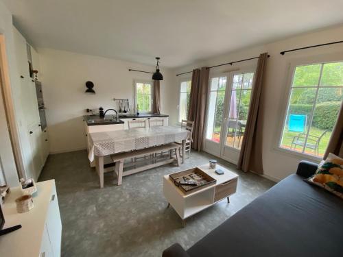 salon z łóżkiem i stołem w obiekcie Maison NAUCALA proche de la piscine w mieście Lacanau