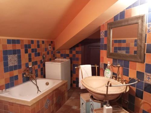 uma casa de banho com um lavatório, uma banheira e um espelho. em LA CASA DI ENZA em Santa Margherita di Belice