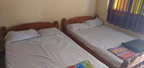 dos camas sentadas una al lado de la otra en una habitación en Coco Beach Gokarna en Gokarna