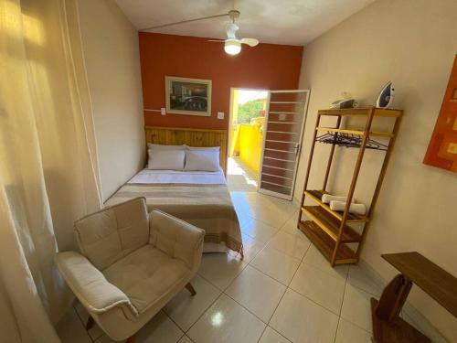 a bedroom with a bed and a chair in a room at Aconchego Mineiro com Garagem in Belo Horizonte