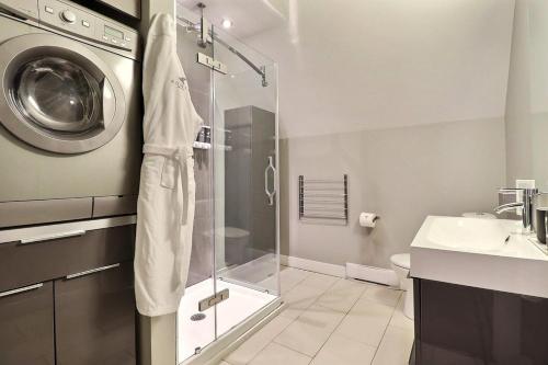 a bathroom with a shower and a washing machine at Château Queen by Bower Boutique Hotels in Moncton