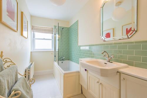 La salle de bains est pourvue d'un lavabo, d'une douche et d'une baignoire. dans l'établissement Valentine's House, à Kent