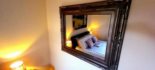 a mirror on a wall with a bed in a room at Wolds View Hideaway in Scarborough