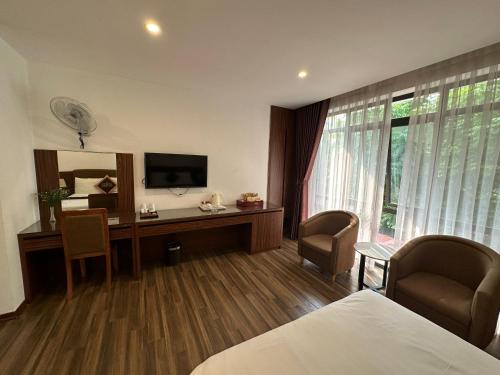 Nhà Nghỉ Thanh Lam ( KĐT Xala ) في هانوي: غرفة فندقية بسرير ومكتب مع تلفزيون