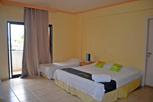 um quarto de hotel com duas camas e uma janela em Hotel Canto do Atlântico no Guarujá