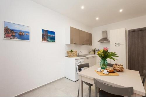 テッラジーニにあるHoliday House Ladyの白いキッチン(テーブル、椅子、カウンター付)