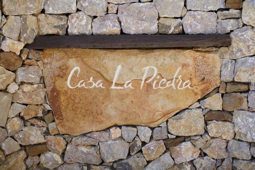 a sign on the side of a stone wall at Apartamentos Rurales Casa la Piedra in Collía