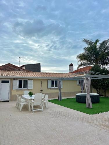 a patio with a table and chairs in front of a house at Nell&And&Jess HOME in Espinho