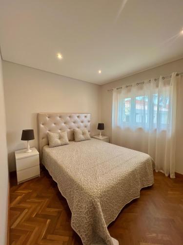 a bedroom with a large bed and a window at Nell&And&Jess HOME in Espinho