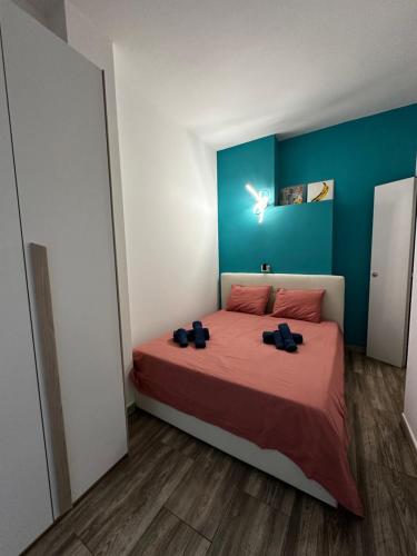 um quarto com uma cama com lençóis vermelhos e paredes azuis em Casa Raf San Salvario em Turim