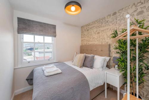 a bedroom with a large bed and a window at Fantastic 3-bed house with parking in Bath