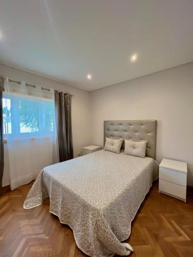 a bedroom with a large bed and a window at Nell&And&Jess HOME in Espinho