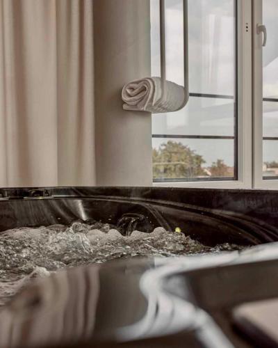 a bathroom with a sink with water in it at SPA apartamentai Palanga in Palanga