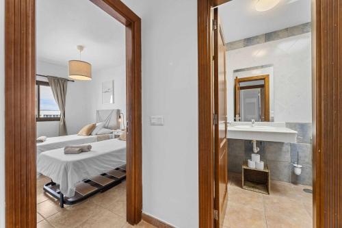 Habitación hospitalaria con cama y espejo en HOLYHOME SunSplash, en Costa Teguise