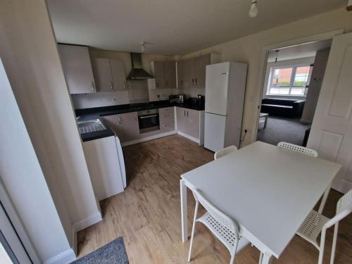 a kitchen with a white table and white appliances at Comfy 3 bed home in Nottingham