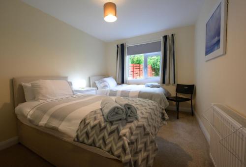 a hotel room with two beds and a window at Ardview Cottage in Oban