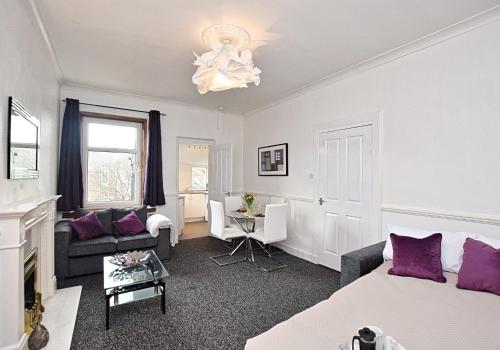 Whifflet Apartment by Klass Living Coatbridge في كوتبريدج: غرفة نوم مع سرير وغرفة معيشة