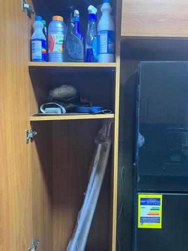 a shelf with bottles on it next to a microwave at Luxurious VIP Apartment in Madinaty Furnished with High End Hotel Furniture in Madinaty