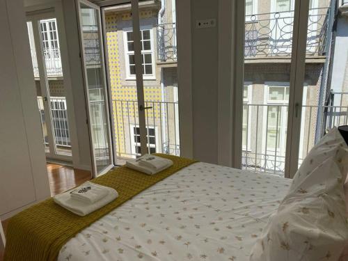 1 dormitorio con 1 cama con 2 toallas en Sweet Home Clerigos Balcony View, en Oporto