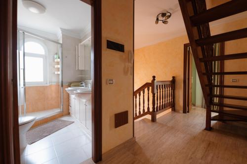 a bathroom with a toilet and a sink and a staircase at Villa Faya Ocean View With Private Pool in Los Cristianos