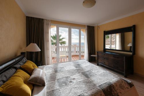 una camera con un grande letto e un grande specchio di Villa Faya Ocean View With Private Pool a Los Cristianos