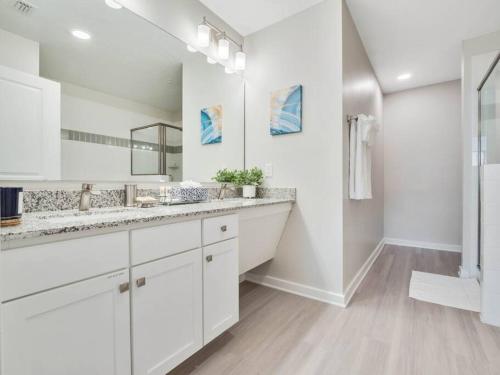 NEW Amazing 3 Bedroom Apartment Vista Cay Resort في أورلاندو: حمام أبيض مع حوض ومرآة