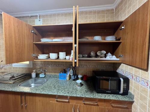 a kitchen counter with a sink and a microwave at Luxurious VIP Apartment in Madinaty Furnished with High End Hotel Furniture in Madinaty