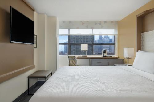 a hotel room with a bed and a desk with a window at Holiday Inn Toronto Downtown Centre by IHG in Toronto