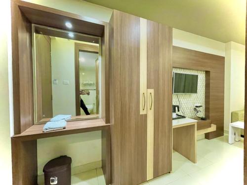 Baño con puerta con espejo y lavabo en Hotel KUBER PALACE ! PURI near-sea-beach-and-temple fully-air-conditioned-hotel with-lift-and-parking-facility, en Puri