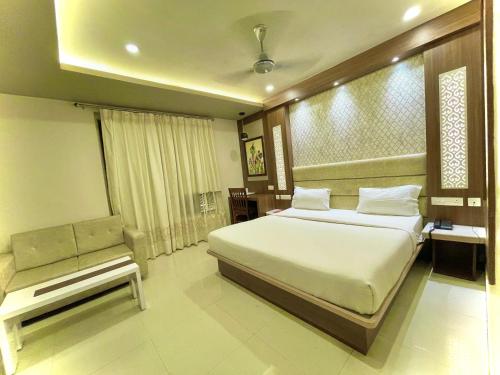 um quarto com uma cama e um banco em Hotel KUBER PALACE ! PURI near-sea-beach-and-temple fully-air-conditioned-hotel with-lift-and-parking-facility em Puri