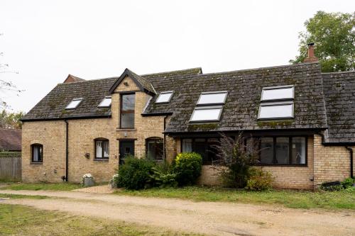 an old brick house with windows on a dirt road at Colthorn Farm Cottage By Aryas Properties - Oxford in Oxford