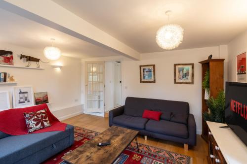uma sala de estar com um sofá e uma mesa em Colthorn Farm Cottage By Aryas Properties - Oxford em Oxford