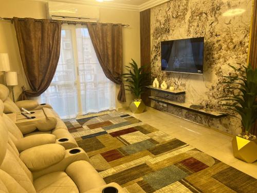 a living room with a couch and a flat screen tv at Luxurious VIP Apartment in Madinaty Furnished with High End Hotel Furniture in Madinaty